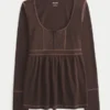 Babydoll-top met lange mouwen en henleykraag Babydoll-top met lange mouwen en henleykraag