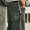 Gewassen zwarte skaterbroek met geborduurde slang Gewassen zwarte skaterbroek met geborduurde slang