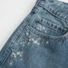 Laag model, donkere wassing, bloemenborduursel, baggy jeans Laag model, donkere wassing, bloemenborduursel, baggy jeans