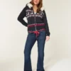 Laag model, donkere wassing, rode strikceintuur, bootcut jeans Laag model, donkere wassing, rode strikceintuur, bootcut jeans