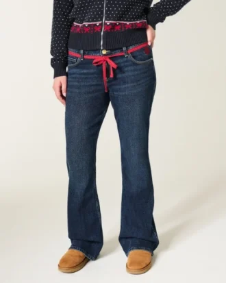 Laag model, donkere wassing, rode strikceintuur, bootcut jeans