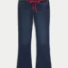 Laag model, donkere wassing, rode strikceintuur, bootcut jeans Laag model, donkere wassing, rode strikceintuur, bootcut jeans