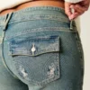 Laag uitgesneden bootcut jeans met vlinderborduursel, medium wash Laag uitgesneden bootcut jeans met vlinderborduursel, medium wash